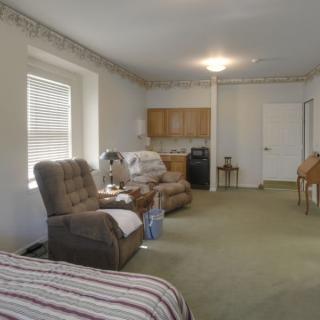 A cozy living room with reclining chairs and a kitchenette.