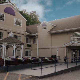 A cozy hotel with a welcoming entrance and gazebo under a clear blue sky.