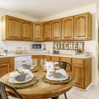 A warm and inviting kitchen with wooden cabinets and a neatly set dining table.