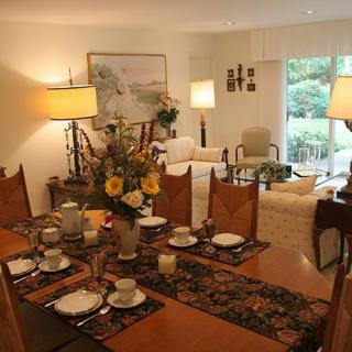A warmly lit dining and living area with a beautifully set table, cozy seating, and tasteful decor.