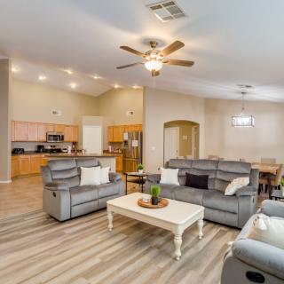 A modern open floor plan living space with a comfortable seating area, adjacent kitchen, and dining area.