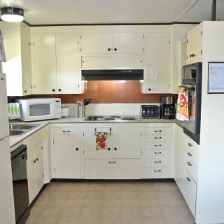 A clean and organized kitchen with white cabinets and modern appliances.