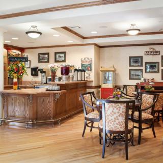 A cozy cafe interior with wooden flooring, tables, and vintage decor.