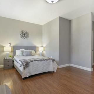 A minimalist bedroom with a bed, nightstands, and wooden flooring.