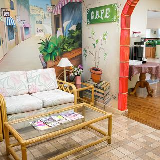 Cozy indoor seating area with a mural and cafe decor.