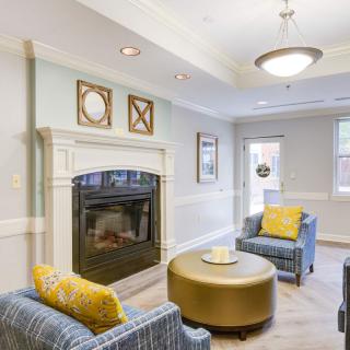 A cozy and modern living room featuring a fireplace, stylish armchairs, and a circular coffee table.