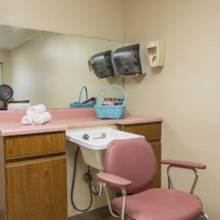 A cozy hair salon setup featuring a comfortable chair, vanity area, and mirror.