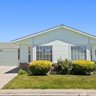 A single-story suburban house with a well-maintained front yard on a sunny day.
