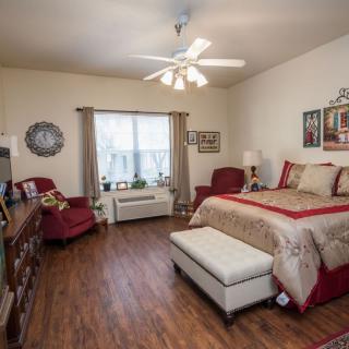 A cozy bedroom with elegant decor and hardwood flooring.
