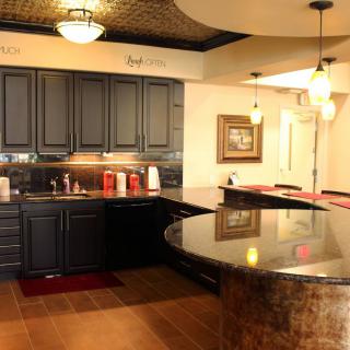 A modern kitchen interior featuring dark cabinets and a large countertop under warm lighting.