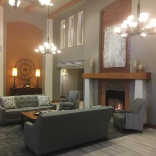 A cozy and elegantly designed lobby space featuring modern furnishings and a warm fireplace.