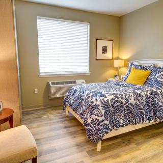 A cozy bedroom with a patterned bedspread and soft lighting.