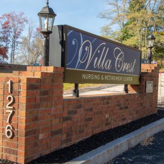 The image shows an outdoor brick sign for 'Villa Crest', indicating a building or community entrance.