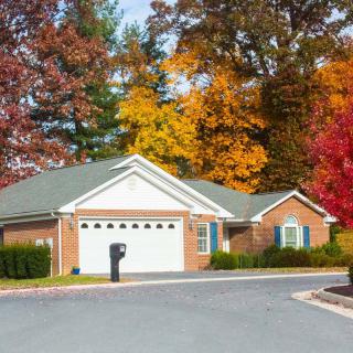 A suburban house surrounded by vibrant autumn foliage.