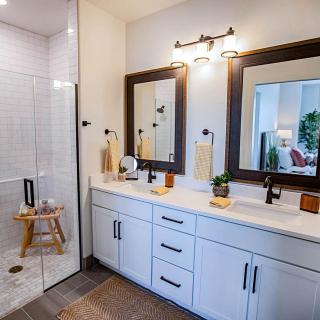 A modern bathroom featuring a double sink vanity with mirrors and stylish lighting.