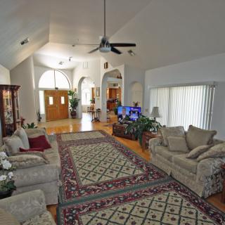 Spacious living room with comfortable seating and a large carpet.
