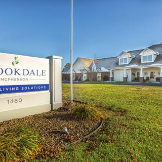 A facility with a sign labeled 'Brookdale' and a well-maintained lawn under a clear blue sky.