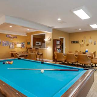 A cozy recreation room featuring a pool table and comfortable seating area.