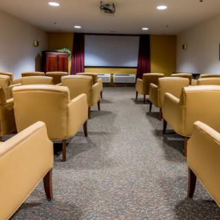 A cozy indoor movie theater with comfortable seating and a large projector screen.