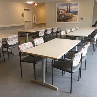 An empty dining room with arranged tables and chairs.