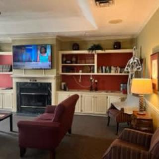 A cozy living room with a TV, fireplace, and comfortable seating.