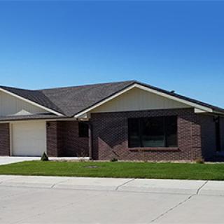 A modern single-family home with a brick exterior and well-maintained lawn.