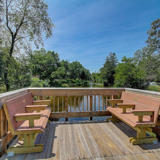 A serene waterfront dock with comfortable seating, perfect for enjoying nature and the calm waters.