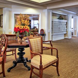 A well-decorated lobby area with wooden furniture and a floral centerpiece.