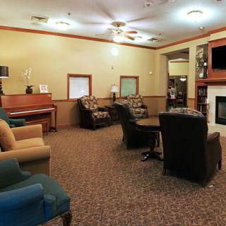 A cozy living room with comfortable seating, a fireplace, and a piano.
