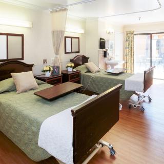A well-appointed hospital room with two beds, featuring a clean and comfortable environment for patient care.