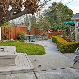 A cozy backyard with a patio, outdoor seating, and a well-maintained garden path.