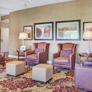A cozy lobby seating area with armchairs and artwork on the walls.