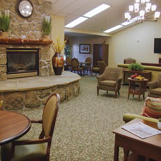 A cozy living room with a fireplace, comfortable seating, and warm lighting.