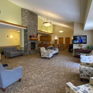 A spacious and comfortable lobby area with seating, a fireplace, and a television.