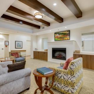 A cozy living room featuring a fireplace, comfortable seating, and decorative artwork.