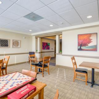A spacious dining area featuring tables, chairs, and colorful artwork on the walls.