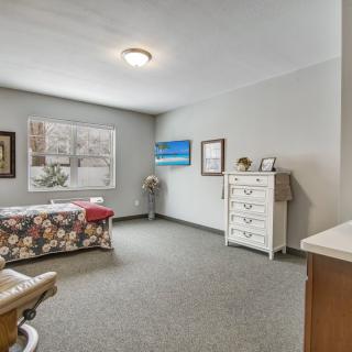 A cozy living space with artwork, furniture, and a carpeted floor.