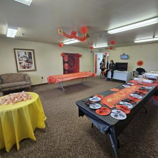 A room decorated for a party with colorful table settings and hanging decorations.