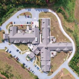 Aerial view of a building complex surrounded by roads and greenery.