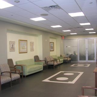 An empty waiting room with seating arrangements and modern lighting.