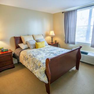 A cozy bedroom with a neatly made bed and ambient lighting.