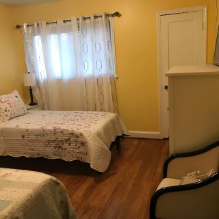 A cozy bedroom with twin beds and warm yellow walls.