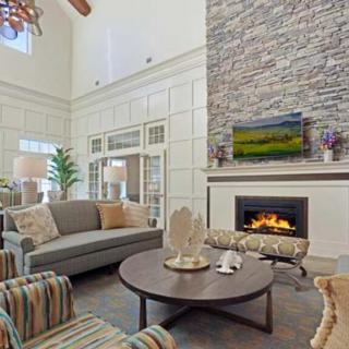A cozy living room featuring a stone fireplace, comfortable seating, and elegant decor.