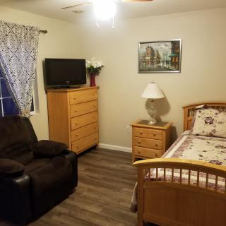 Cozy bedroom with wooden furniture and a TV.