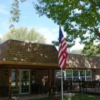 A building with an American flag outside, surrounded by trees and a deck.