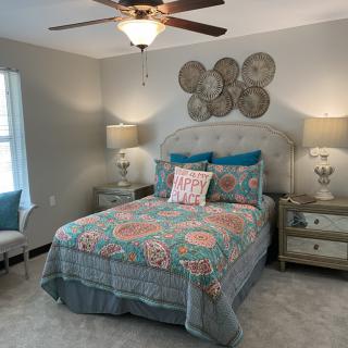 A cozy bedroom with colorful bedding and stylish decor.