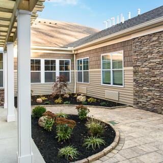A beautifully landscaped patio with plants and a stone wall.