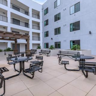 Modern apartment courtyard with tables and chairs for outdoor seating.