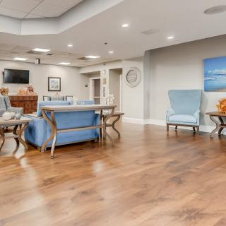 A modern and spacious living room with comfortable seating and a hardwood floor.
