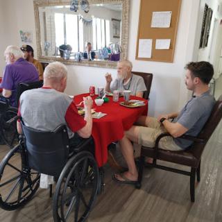 A group of elderly individuals enjoying a meal together in a cozy dining area.